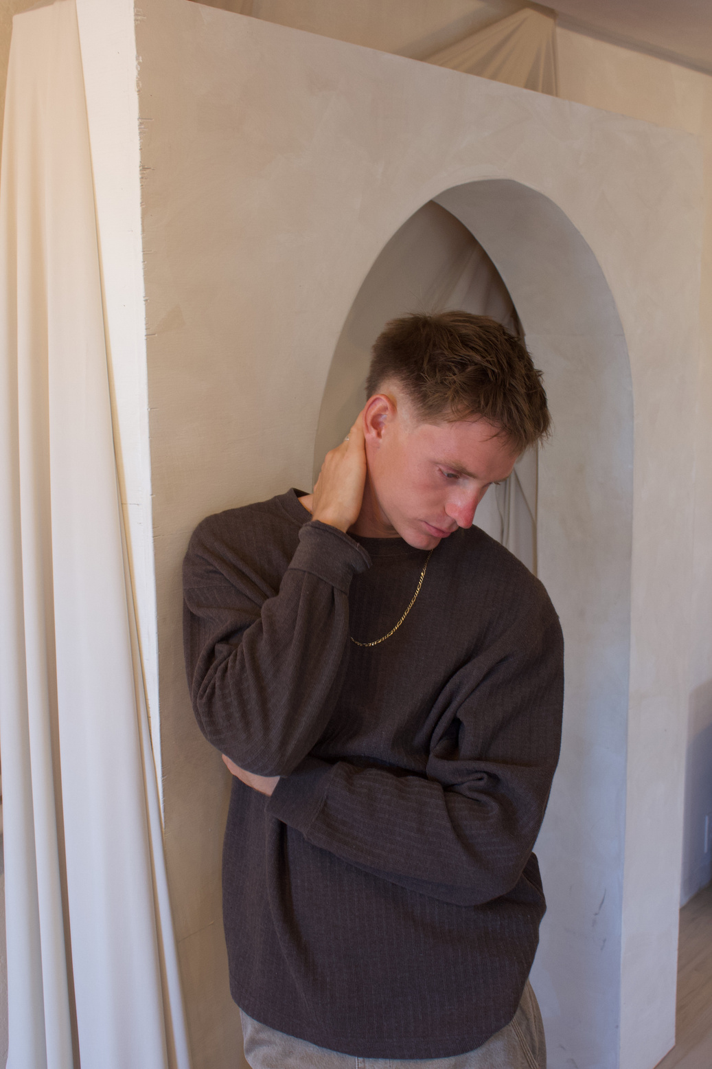Portrait in a brown knit against draped fabric